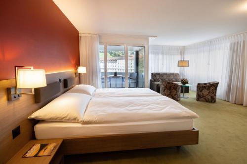ein Schlafzimmer mit einem großen weißen Bett in einem Zimmer in der Unterkunft Hotel Drei Könige in Einsiedeln