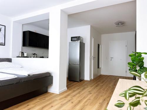a bedroom with a refrigerator in a white room at Schöne Apartments I private Parkplätze I home2share in Münster