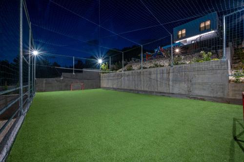 an empty soccer field at night with lights at Villa GRC in Zaboric