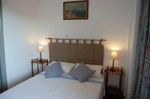1 dormitorio con 1 cama blanca grande y 2 lámparas en VILLA DOLPHIN VOTSI, en Votsi
