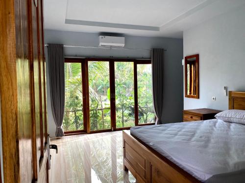 a bedroom with a bed and a large window at Adventure Turtle Homestay Meru Betiri in Sarungan