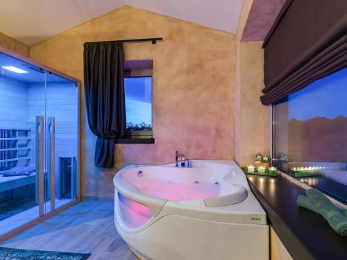 a large bathroom with a tub and a large window at Vila Maslina in Nova Vas