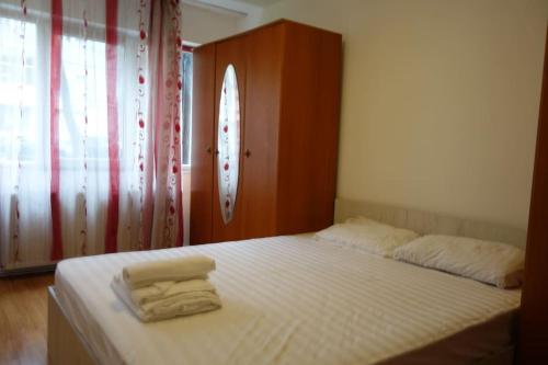 a bed with two towels on it in a bedroom at Joy City Stay Torontalului 1 in Timişoara