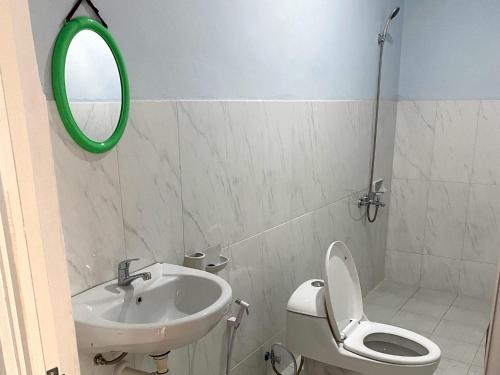 a bathroom with a sink and a toilet and a mirror at Adventure Turtle Homestay Meru Betiri in Sarungan