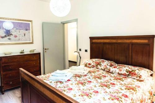 a bedroom with a bed with a floral bedspread at Patty’s House [Centro storico a 5 min] in Pesaro
