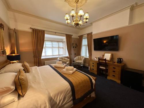 Dormitorio con cama, escritorio y TV en Chester Court Hotel, en Chester