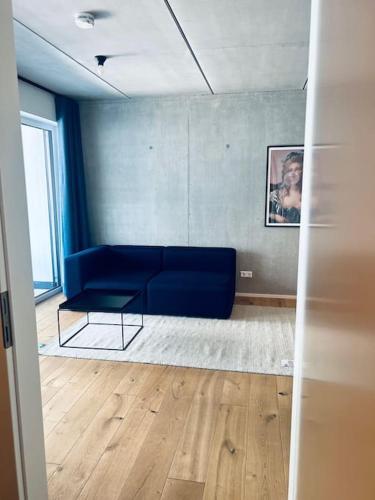 a living room with a blue couch in a room at Studio Eleven in Tettnang