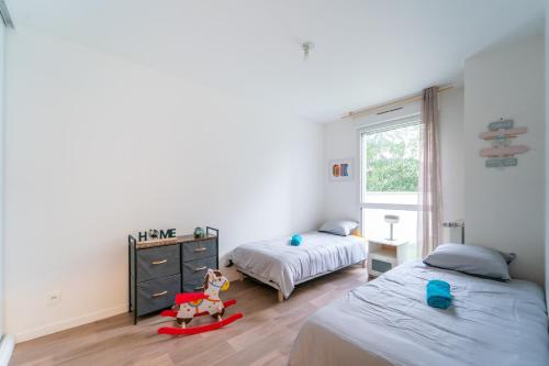 um quarto com duas camas e um brinquedo de cavalo no meio em Le Arty - 20 mn de Paris et d'Orly em Vitry-sur-Seine