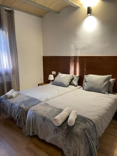 two beds in a bedroom with towels on them at Casa de la Mestra, Espinalbet - ALBERGA in Castellar del Riu
