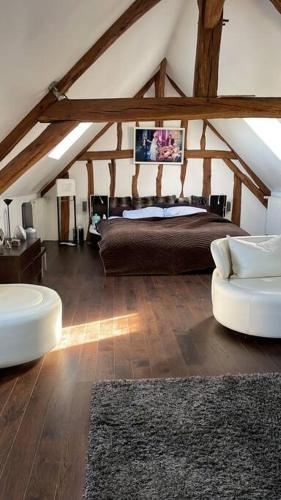 une chambre avec un grand lit dans un grenier dans l'établissement Maison familiale à la campagne, à Dollot