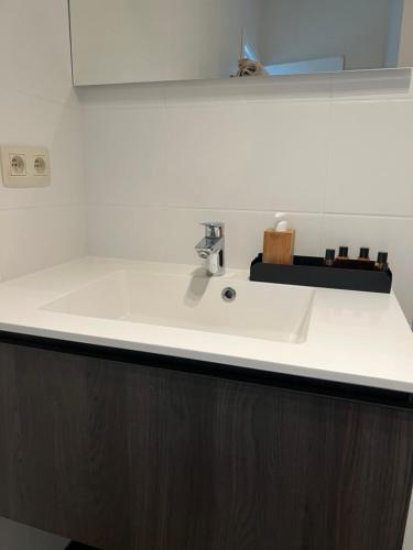 a bathroom counter with a white sink and a mirror at K&Y suites 2 ,500m to Brussels airport! in Zaventem