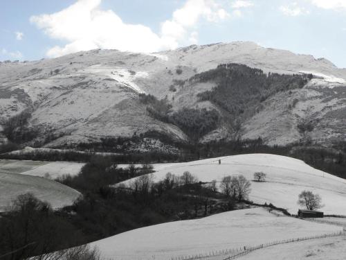 a snow covered hill with a mountain in the background at Pena plata in Sare