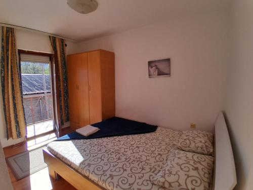 ein kleines Schlafzimmer mit einem Bett und einem Fenster in der Unterkunft Airport ROOMS NIKKI in Belgrad