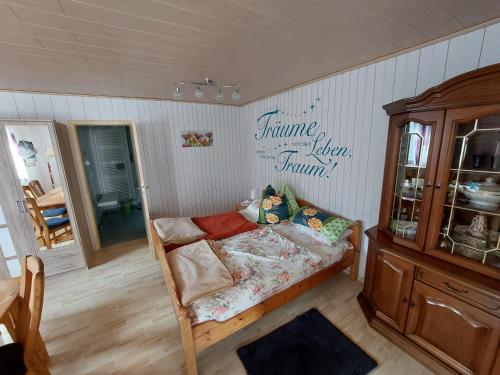 a bedroom with a bed and a dresser in it at Landhauswohnung am Thüringer Meer mit Whirlpool-Fühlen wie Zuhause 