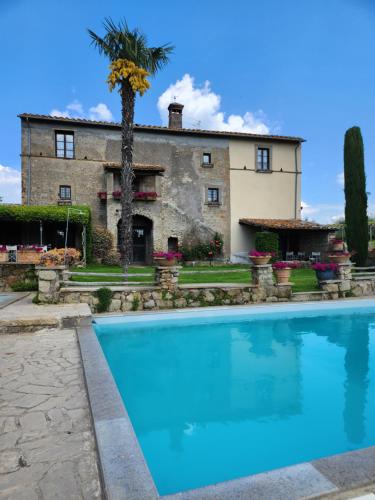 a villa with a swimming pool in front of a house at Villa Arzilla Antica Residenza di campagna in Vitorchiano