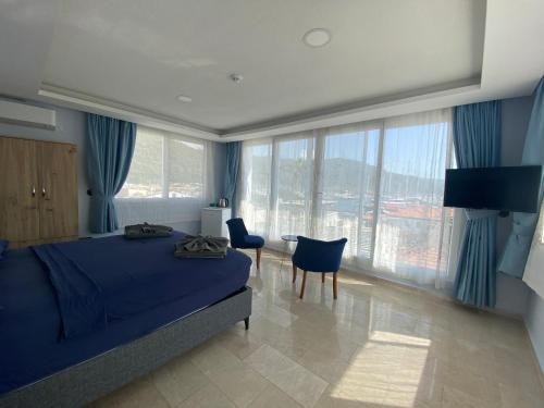 Schlafzimmer mit einem blauen Bett, einem Tisch und Stühlen in der Unterkunft Mert Homes Marmaris in Marmaris