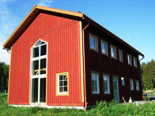 a red and black house with white windows at Allsta Gård Kretsloppshuset B&B in Bjärtrå