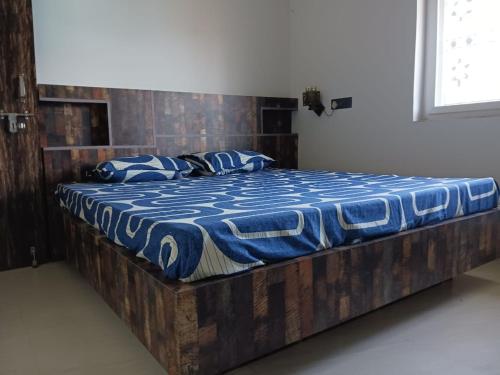 ein Bett mit einem Holzrahmen in einem Zimmer in der Unterkunft Vaidhya homes in Deoghar
