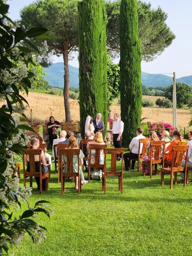 a group of people sitting in chairs in the grass at Villa Arzilla Antica Residenza di campagna in Vitorchiano