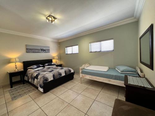 1 dormitorio con cama y banco. en Nomland en Walvis Bay