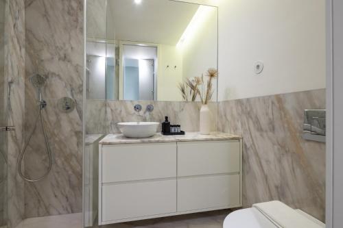 a white bathroom with a sink and a shower at ORM Batalha Apartments in Porto