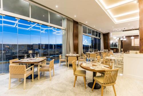 a restaurant with tables and chairs and large windows at Hyatt Regency San Luis Potosi in San Luis Potosí