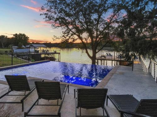 a swimming pool with chairs and a body of water at LBJ Bliss Retreat Heated Pool Hot Tub Game Rooms in Burnet