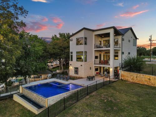 a large house with a swimming pool in the backyard at LBJ Bliss Retreat Heated Pool Hot Tub Game Rooms in Burnet