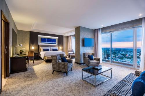 Habitación de hotel con cama y ventana grande en Hyatt Regency San Luis Potosi en San Luis Potosí