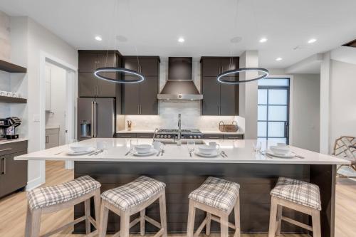 a kitchen with a large white island with bar stools at LBJ Bliss Retreat Heated Pool Hot Tub Game Rooms in Burnet