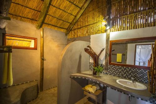 a bathroom with a sink and a mirror at Covane Community Lodge in Lagoa Nova