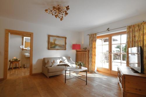 a living room with a couch and a table at Hotel Maier zum Kirschner in Rottach-Egern