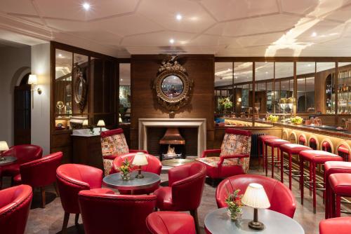 a restaurant with red chairs and a fireplace at The White Hart Hotel Lincoln in Lincoln