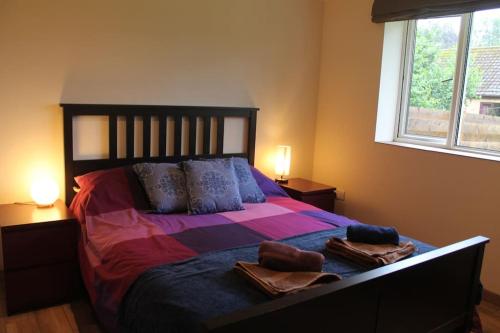 1 dormitorio con 1 cama grande y 2 toallas. en The Walled Garden, en Long Melford