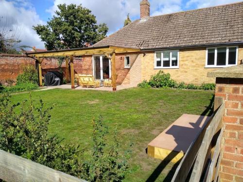 una imagen de una casa con un patio en The Walled Garden en Long Melford