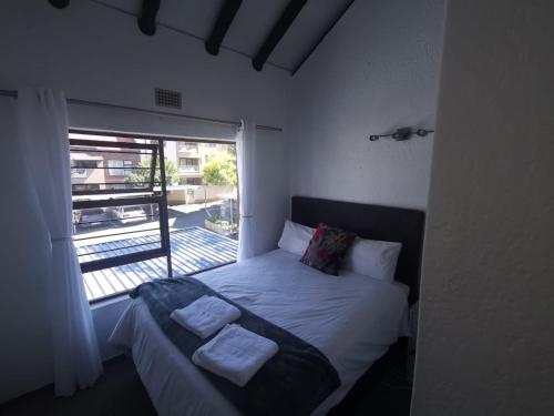 um quarto com uma cama com duas toalhas em Paulshof Sandton Apartments - Monchique em Sandown