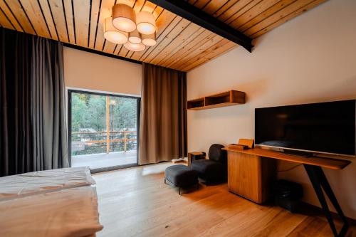 a bedroom with a bed and a flat screen tv at Complexul Turistic Cheile Butii in Cîmpu lui Neag