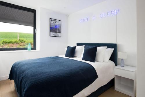 a bedroom with a bed with a blue blanket and a window at 2 The Bay in Coldingham