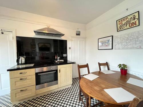 a kitchen with a wooden table and a dining room at 2BR Edwardian House in Greenwich in Abbey Wood