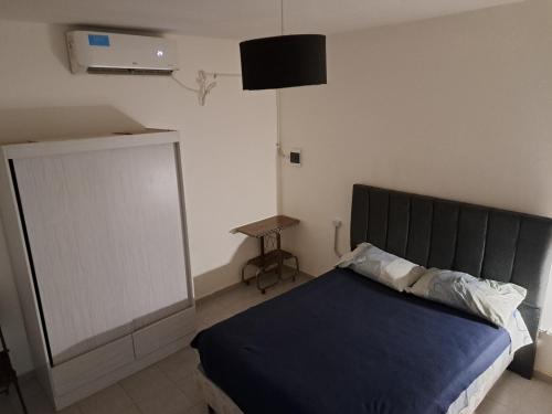een slaapkamer met een bed met een zwart hoofdeinde en een tafel bij Samay kusy 2 in La Rioja