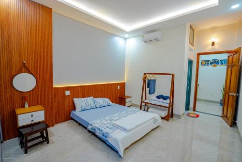 Schlafzimmer mit einem Bett und einem Spiegel in der Unterkunft QUYNHƠN HOMESTAY11B-HAI BÀ TRƯNG in Quy Nhon