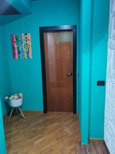 a door in a room with blue walls and wooden floors at b b desy in Caserta