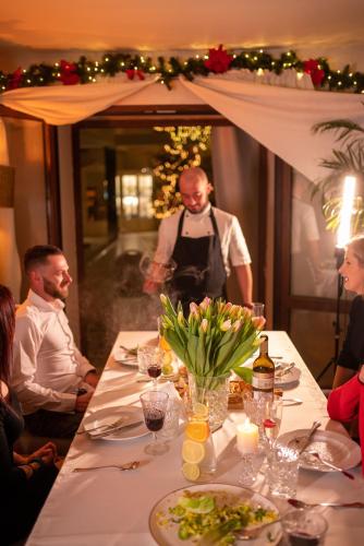 a group of people sitting around a table with a waiter at Na Górce in Przemyśl