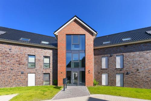 a red brick building with a black roof at Ferienwohnung Ankerpause in Esens