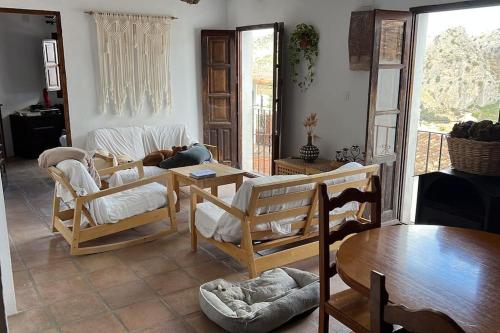 Casa Rural con vistas espectaculares في مونتيخاكي: غرفة معيشة مع كراسي خشبية وطاولة