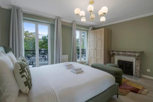 a bedroom with a large white bed and a fireplace at AmazingApartment#4Bedrooms#Bastille#PlaceDesVosges in Paris