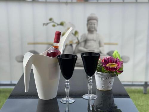 een tafel met twee glazen en een fles wijn bij Berg Messe OG, 2 Zimmer, Homeoffice, W-Lan 