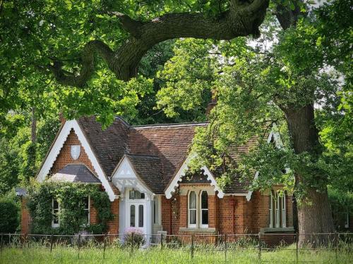 una casa di mattoni con un albero di fronte di Gorgeous Country Cottage overlooking Windsor Castle a Old Windsor