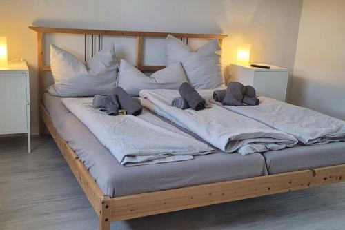 een groot bed met witte lakens en kussens erop bij Berg Messe OG, 2 Zimmer, Homeoffice, W-Lan 