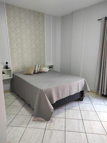 1 cama en un dormitorio con suelo de baldosa en APTO 50M PRAIA- 4 PESSOAS, WIFI, SACADA, CHURRASQUEIRA, GARAGEM PARA VEICULOS PEQUENOS - Residencial Roveda, en Bombinhas